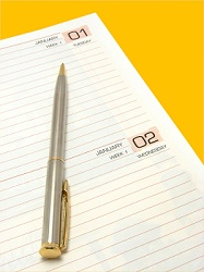 Image showing first January on a diary with pen on isolated color background with fine clipping path.