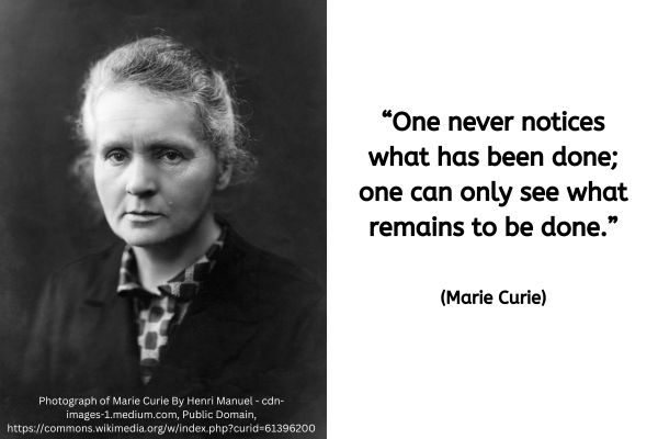 This image is split in two, on the righthand side is a quote - black text on a white background. On the left is a black and white photo of Marie Curie. It was taken around 1920 when she would have been in her early 50s. It shows a white woman sat at a slight angle facing the left but with her turning to look directly at the camera. Her hair is tied back with some whisps of hair escaping. She is wearinf a collared blouse witha light background and a square pattern. A black jacket is being warn fastened over this.
The text reads: "One never notices what has been done; one can only see what remains to be done." (Marie Curie)