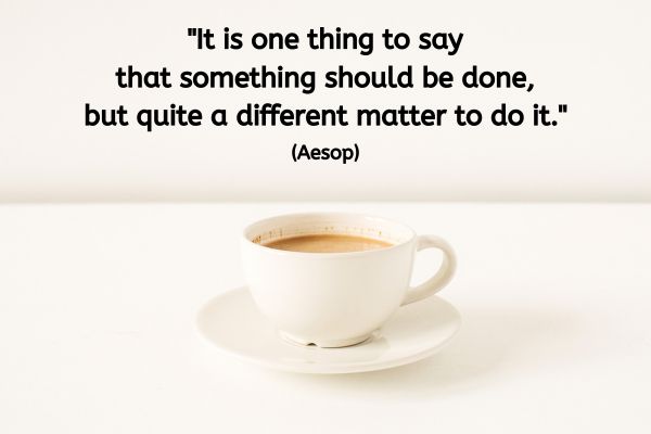 A cup of coffee in a white cup and saucer is sat on a table. The text reads: "It is one thing to say that something should be done, but quite a different matter to do it." (Aesop)