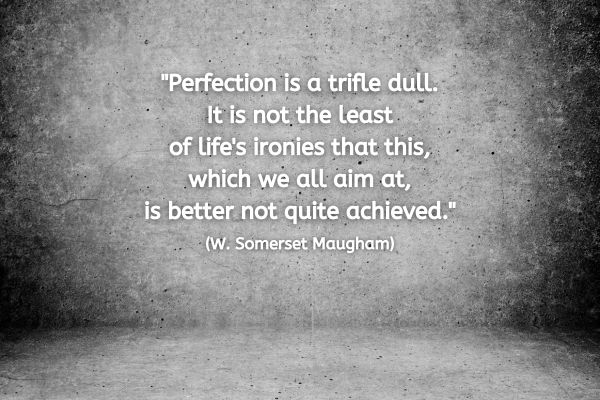 The image has a textured gray concrete background with subtle lighting, giving it a rough, industrial feel. In the centre, there is white text in a simple font that reads: "Perfection is a trifle dull. It is not the least of life's ironies that this, which we all aim at, is better not quite achieved." This quote is attributed to W. Somerset Maugham.